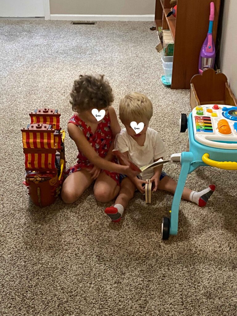 girl reads to boy