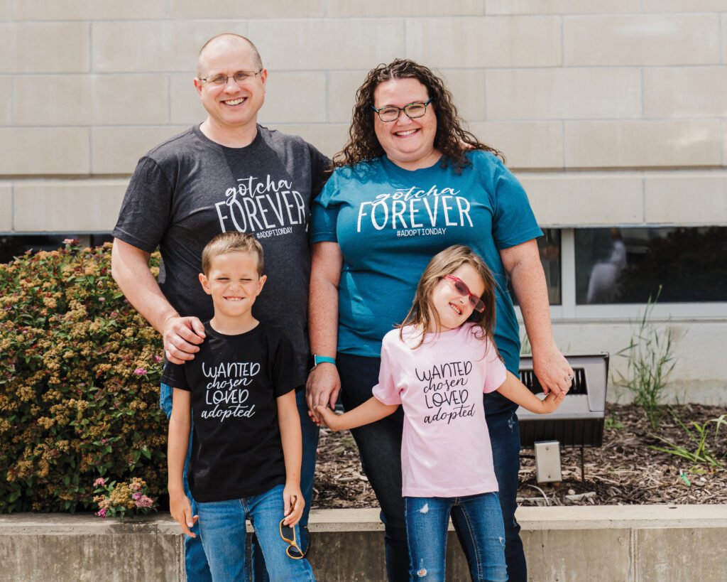 A foster and adoptive family poses in front of a courthouse after finalizing the adoption of two of their children.