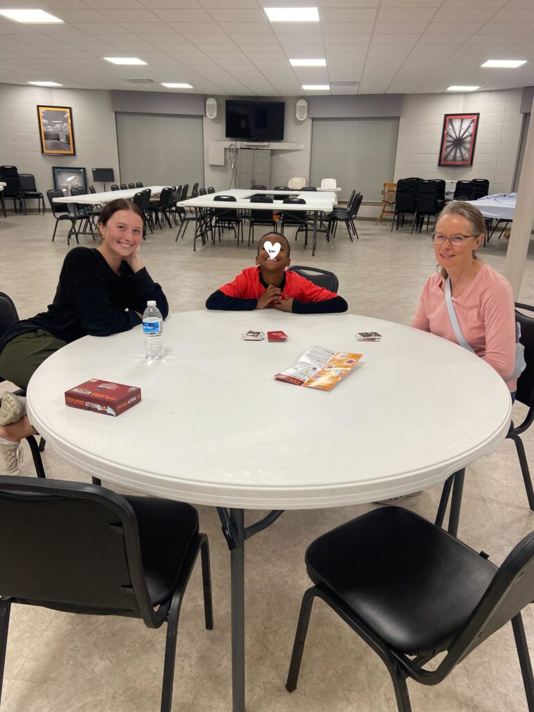 Two volunteers sit with a child at one of Coyote Hill's foster parent community groups. 
