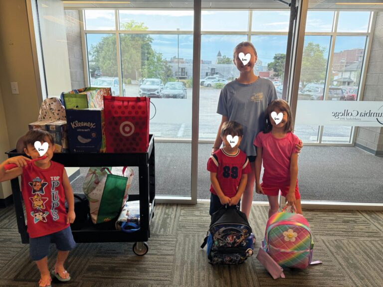 children pose with school supplies